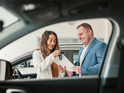 two people holding new car document