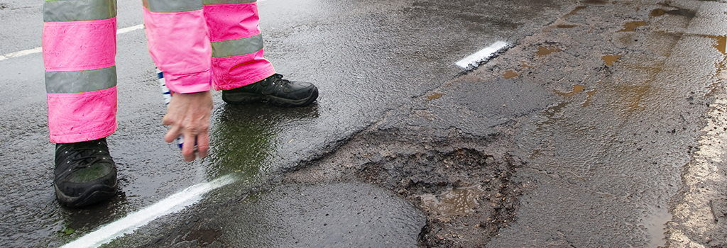 Workmen marking potholes for repair