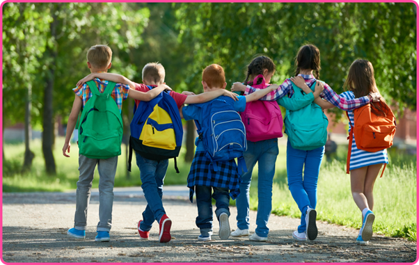 Six children walking away from camera along a park footpath with their arms around each others shoulders